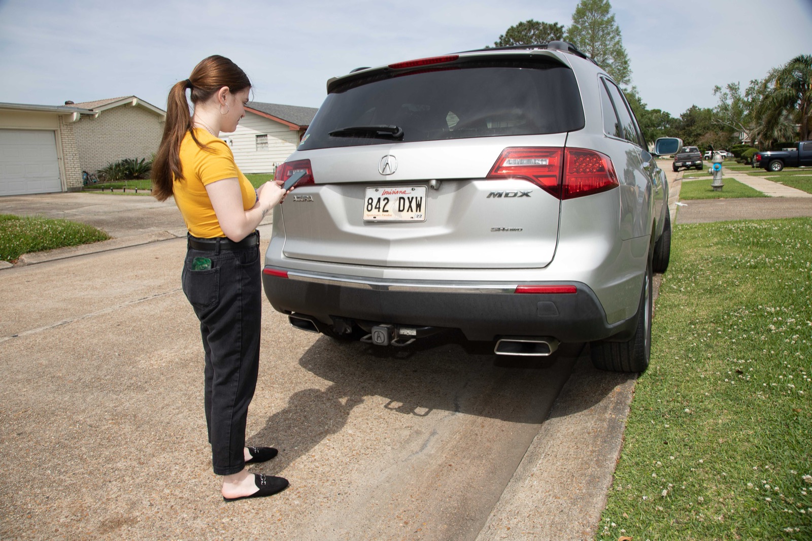 A Louisiana driver photographing her vehicle's rear license plate to enrol in the program — no new transponder required, just the phone she already carries